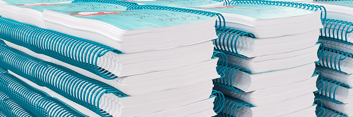 finished books with hole punching and plastic coil applied